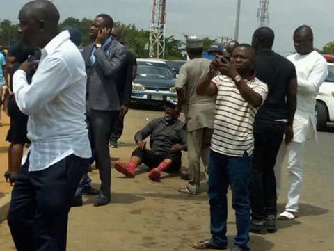 Senator Dino Melaye, sitting on the floor after jumping out of a moving police van